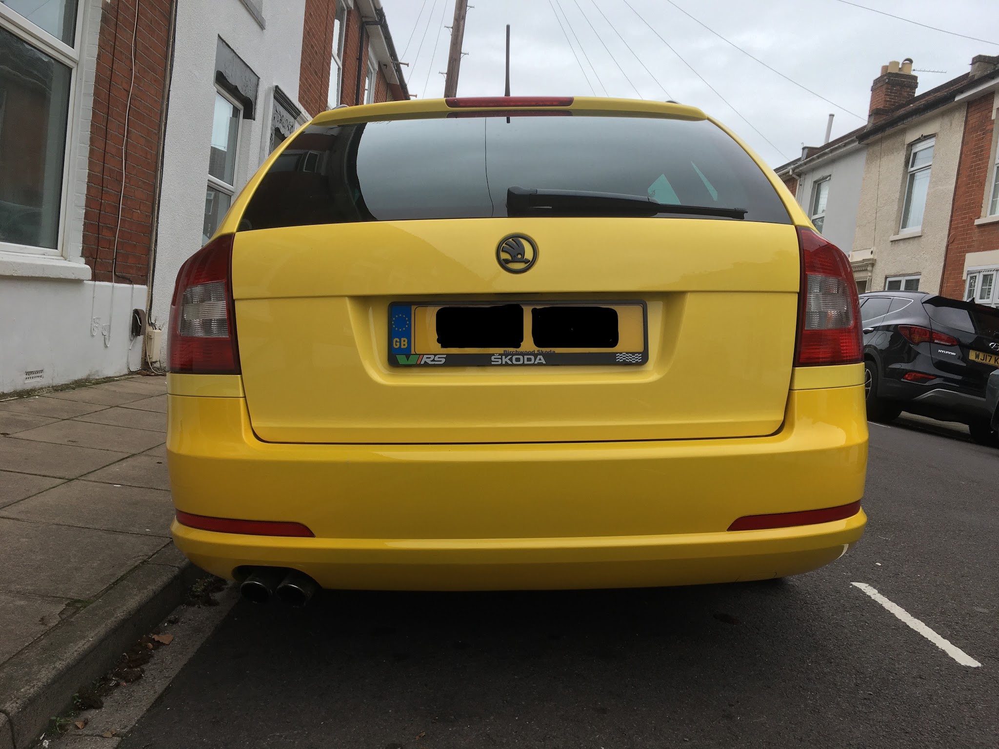 Rear view of a yellow Skoda Octavia vRS estate with a flawless finish after repair
